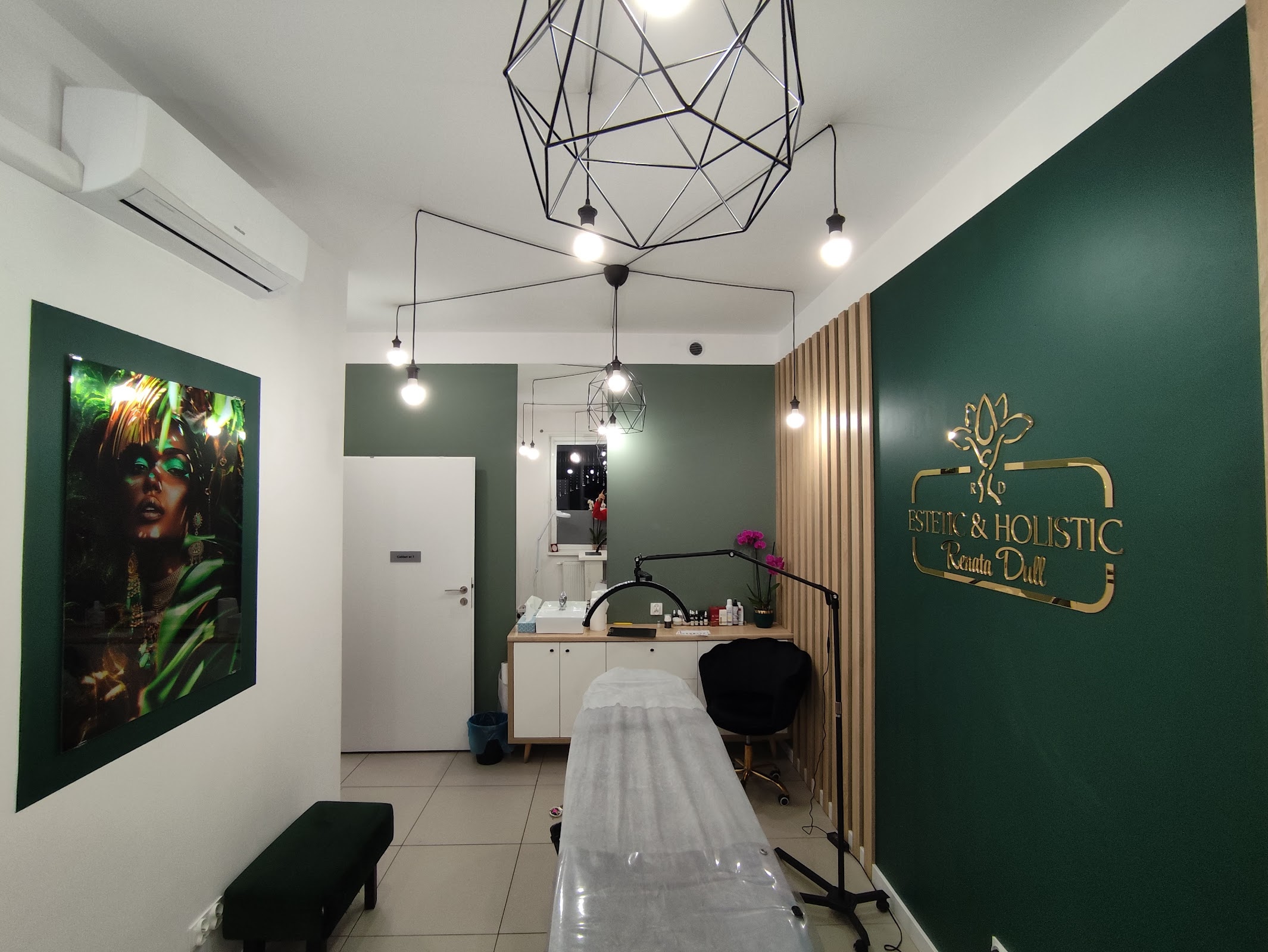 Druga część gabinetu z gold logo na zielonej ścianie, biophilic obraz, klimat eco-spa